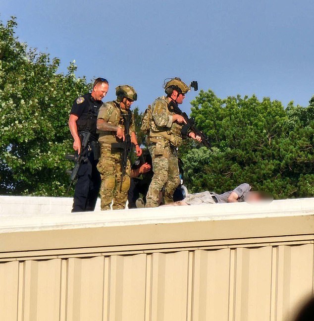 Security personnel stand above the body of the shooter on a roof at the Trump rally. Cheatle said she did not send officers to this roof because of the slope and the safety risks such a surface poses