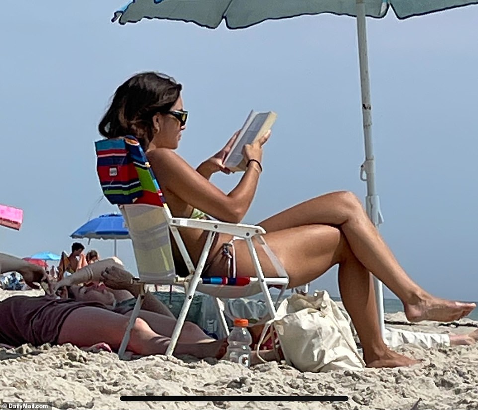 Dressed in a brown, tiny bikini, she looked relaxed and carefree as she lounged on the sand, reading, sunbathing and taking naps