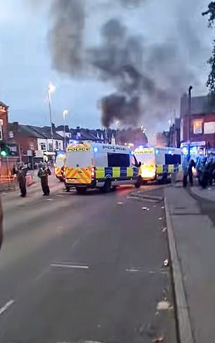 Riot police officers are seen at the crime scene in Harehills as unrest continues