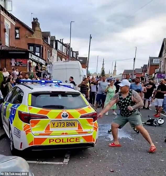 Glass and debris lie on the street as gangs of criminals vandalize a police car