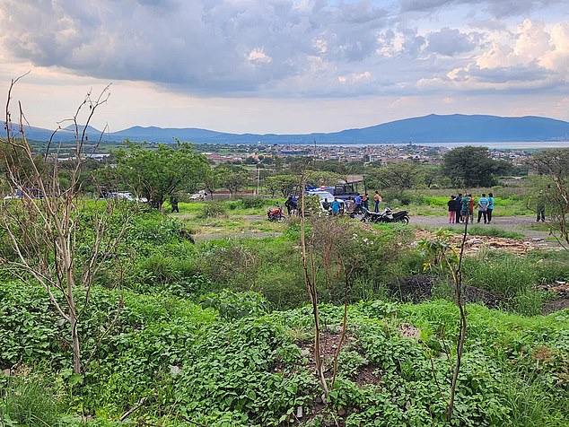 Residents stand behind a perimeter set up by police in the central Mexican municipality of Yuriria, where six members of two families were killed at a construction site on Tuesday. No arrests have been reported