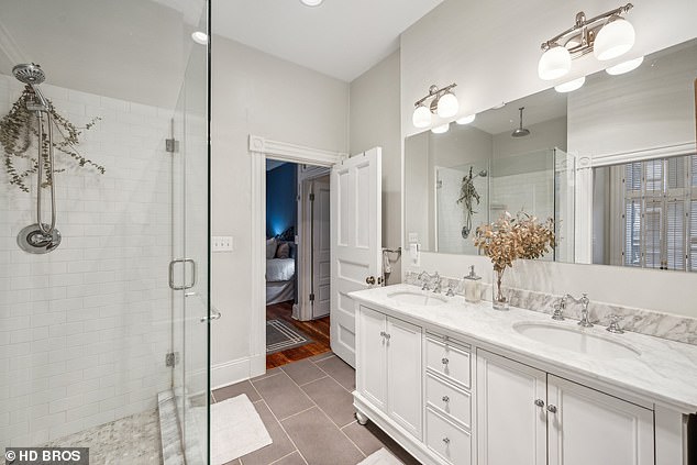 The master bathroom is completely white and marble and has a double sink