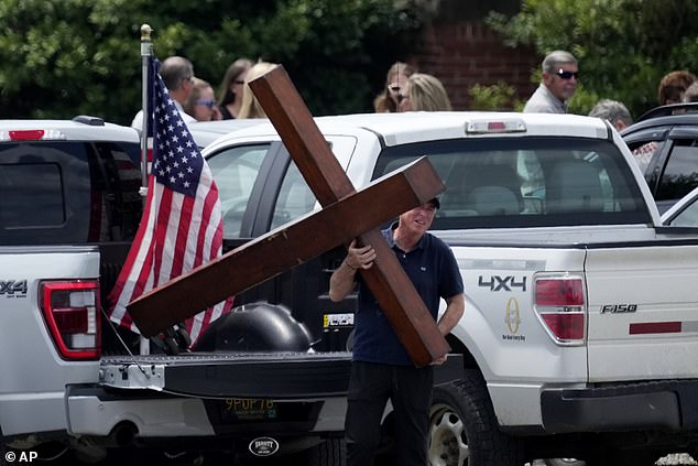 Dan Beazley unloads a cross to a line of guests during a visit with Corey Comperatore at Laube Hall, Thursday, July 18, 2024, in Freeport, Pennsylvania.