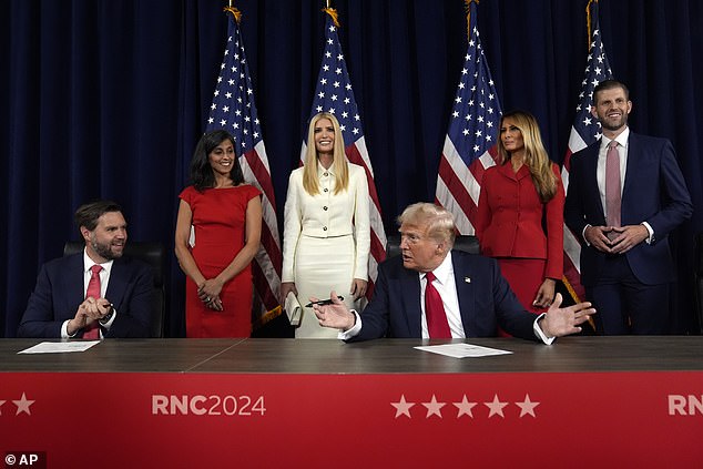 As Usha Chilukuri Vance, Ivanka Trump, former first lady Melania Trump and Eric Trump look on, Republican presidential candidate former President Donald Trump and Republican vice presidential candidate Sen. J.D. Vance, R-Ohio, sign documents to officially accept the nomination