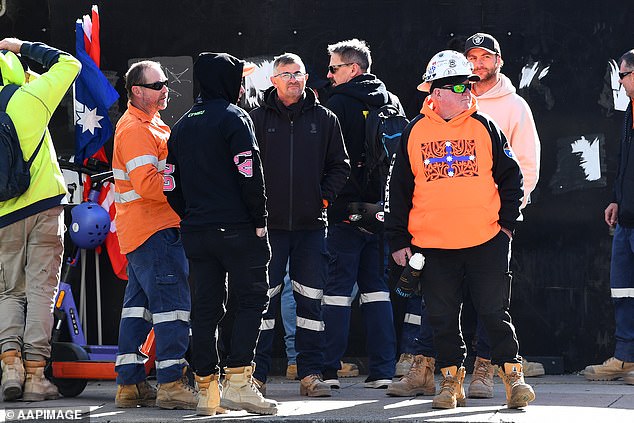 CFMEU union members hold a protest to block access to a construction site in Brisbane, above