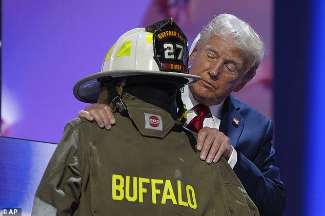 Trump stands wearing the uniform of Corey Comperatore, who was shot dead when the gunman opened fire at the former president's rally in Butler, PA on Saturday