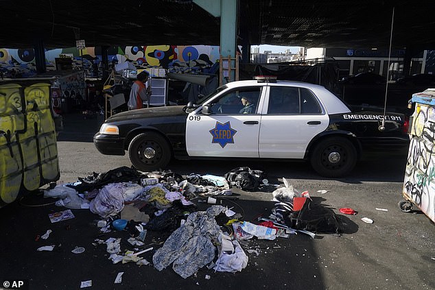 A San Francisco Police Department vehicle drives through a homeless camp being cleared in San Francisco