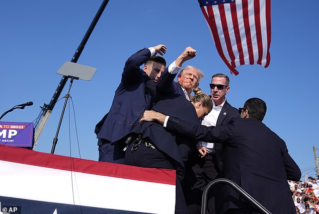 Republican presidential candidate and former President Donald Trump gestures as he is surrounded by U.S. Secret Service agents as he leaves the stage during a campaign rally, Saturday, July 13, 2024, in Butler, Pennsylvania