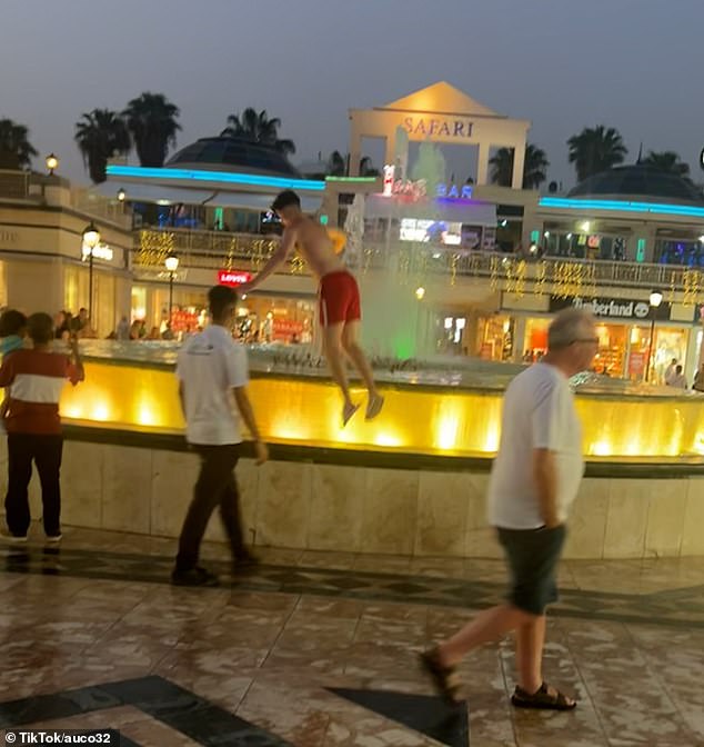 He jumped from the edge of the water feature into the fountain before being dragged away by a staff member and then by a security guard