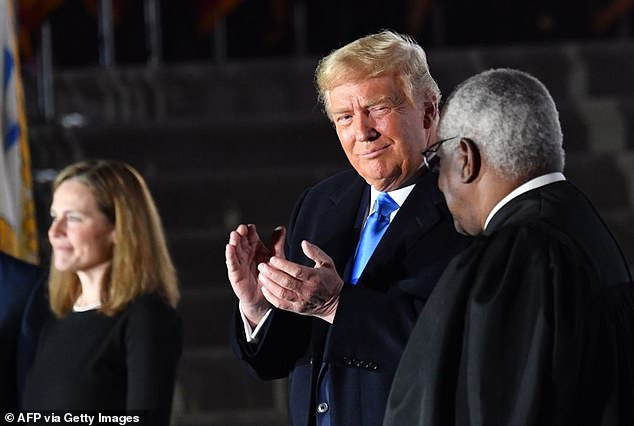 U.S. President Donald Trump applauds alongside Supreme Court Justice Clarence Thomas and Justice Amy Coney Barrett, who was just sworn in as a Supreme Court Justice, during a ceremony on the South Lawn of the White House on October 26, 2020 in Washington, D.C.