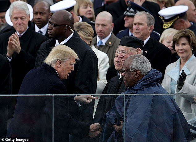 President Donald Trump shakes hands with Supreme Court Justice Clarence Thomas on the west front of the U.S. Capitol on January 20, 2017