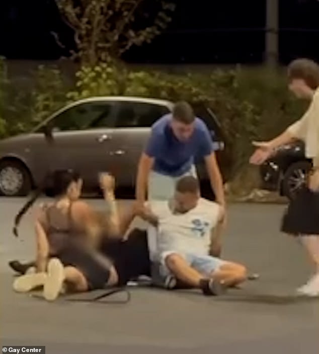 Eventually, passers-by stopped to intervene as the attacker in blue attempted to lift his fellow attacker in white off the ground, while the gay man in black remained on the ground beneath the female attacker.