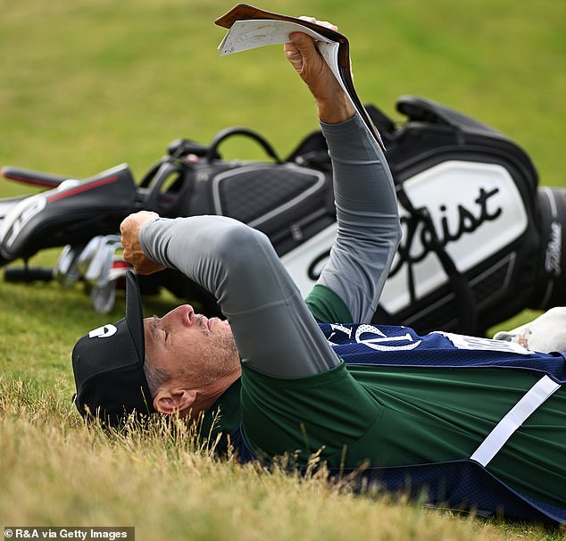 Scott, 39, looks at a map of Royal Troon's 45-hole course during the sixth hole on Friday