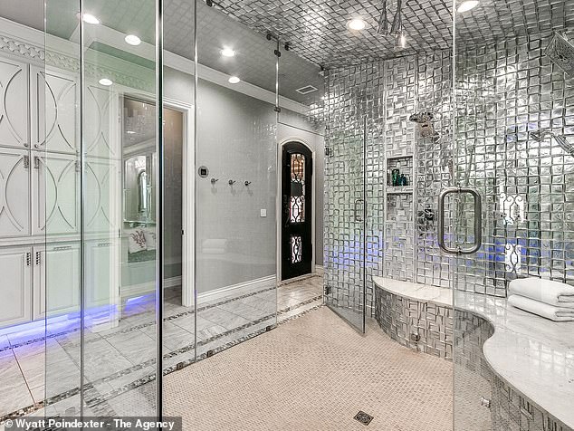 One of the bathrooms has a metallic silver wall and a glass exterior