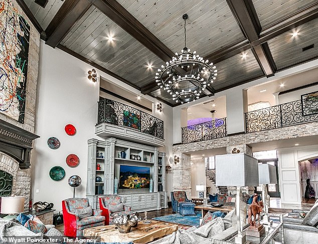 One of the living areas has a rustic look with soft wood tones and a stone fireplace