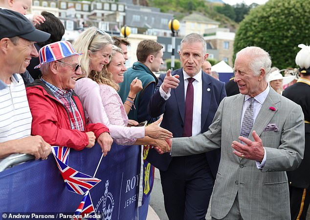 A member of the royal security force urges the king to keep walking as he is taken to safety