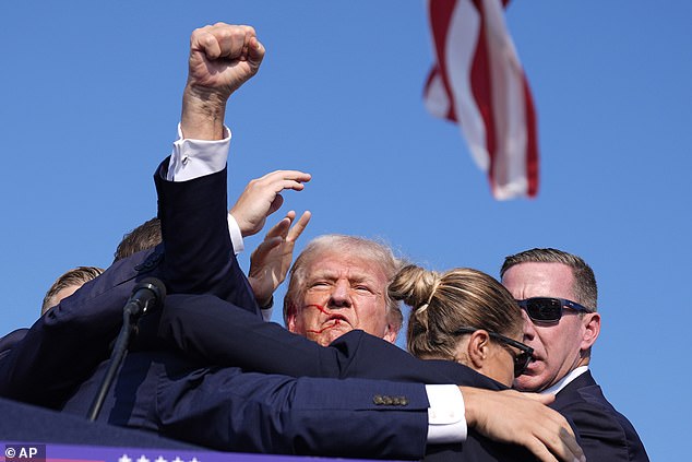 Donald Trump (pictured) narrowly escaped being killed by a gunman at a rally on Saturday, when he was hit in the ear as he tried to turn his back at the last moment.