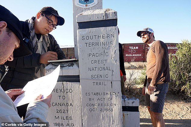 Backpackers sign in for their logbook at the Southern Terminus along the U.S.-Mexico border in Campo, California