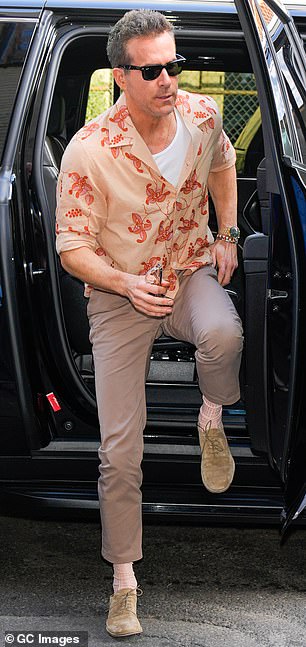 Reynolds, 47, wore a short, buttoned brown shirt with a red floral motif