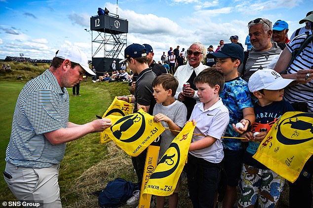 Scotland's Robert MacIntyre signs autographs for fans during a training session