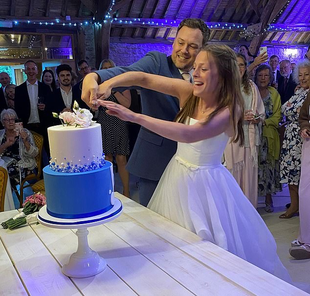 Elizabeth and David Slade are pictured cutting the cake on their wedding day