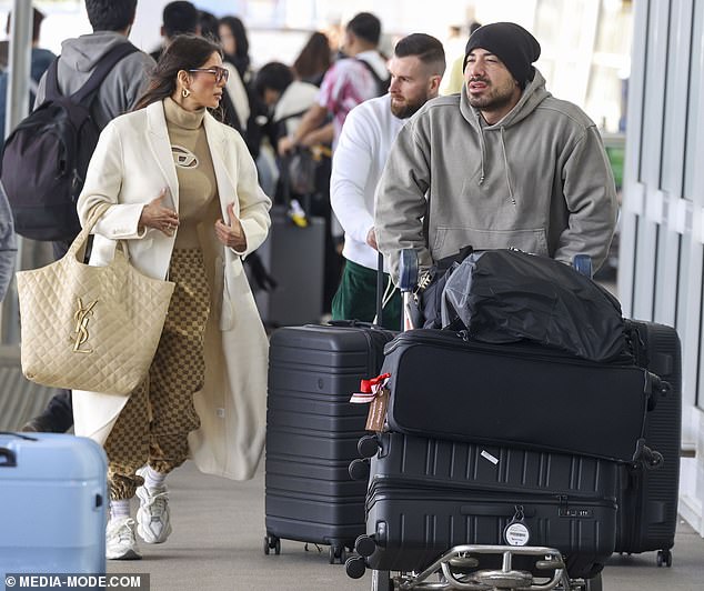 Amy (pictured with Jono and Aaron) looked effortlessly stylish in a beige turtleneck and checked trousers, which she paired with a stylish cream jacket