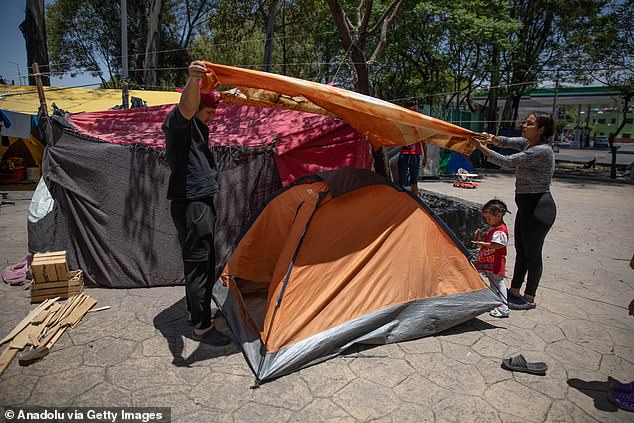 A migrant from Venezuela and his wife set up a tent in a makeshift camp of shelters, on the median strip of Eje Central Avenue, in Mexico City, Mexico, on June 18.