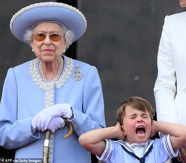 Prince George is seen with his ears covered next to Queen Elizabeth on the balcony of Buckingham Palace during the flypast to mark her Platinum Jubilee, June 2, 2022