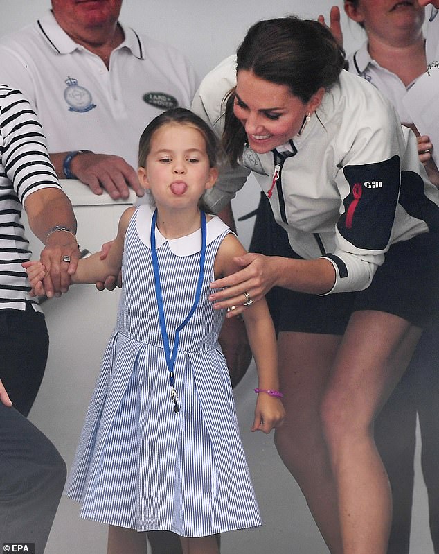 Kate tries to distract her naughty daughter Charlotte as she sticks her tongue out at the crowd during the King's Cup sailing regatta off the Isle of White in 2019. Kate and William were taking part in the race