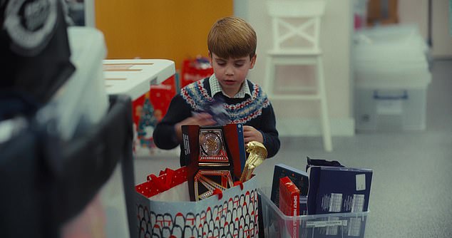 Louis, who also volunteers at the baby bank, struggles to contain his excitement as he browses through a selection of shiny new toys