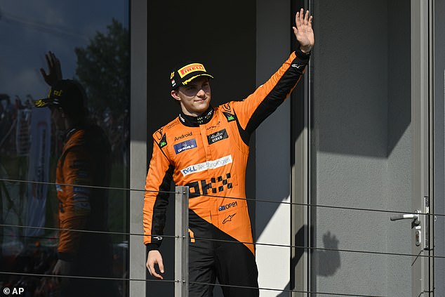 Piastri celebrates his victory by waving to the crowd at the Hungaroring circuit