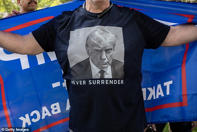 A Trump supporter wears a T-shirt with a photo of former President Donald Trump's arrest photo