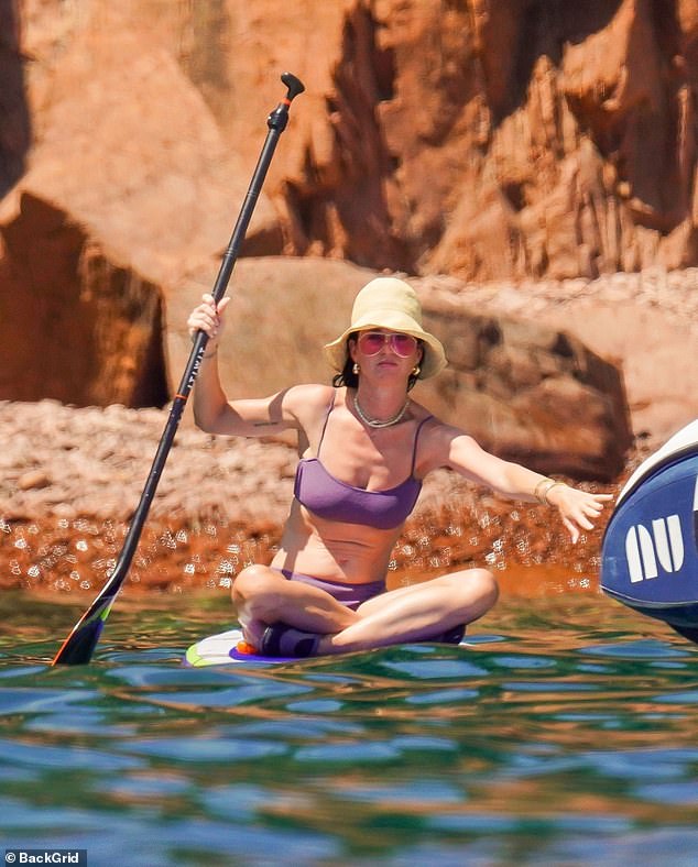 Katy wore a sexy purple bikini as she entered the water