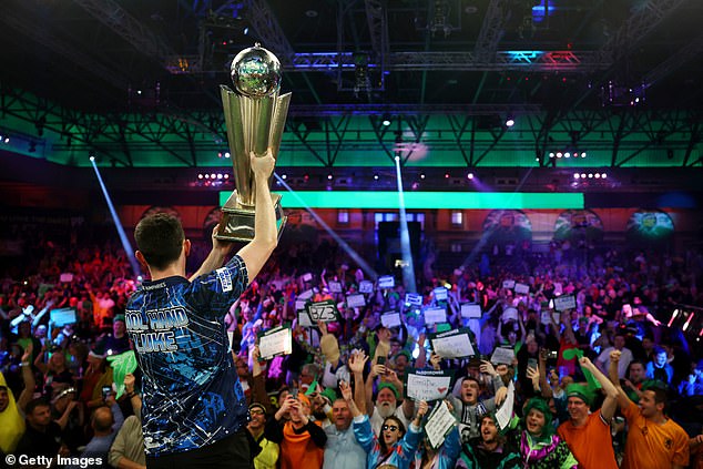 Humphries pictured holding up the World Championship trophy at Alexandra Palace this year. Greaves turned down an offer to play in this year's men's event at the iconic venue