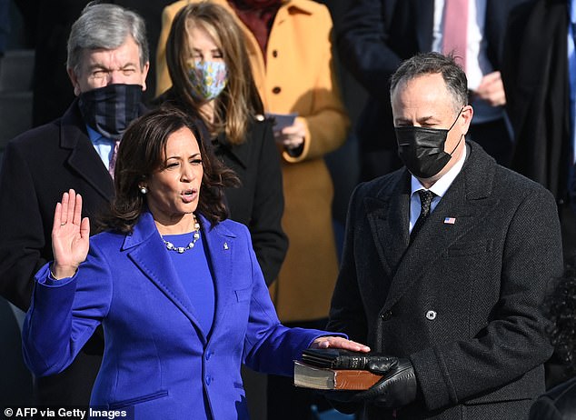 Doug Emhoff holds the Bible as his wife Kamala Harris is sworn in as the first female Vice President of the United States by Supreme Court Justice Sonia Sotomayor on January 20, 2021