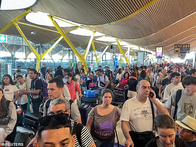 Passengers wait at Barajas airport as Spanish airport operator Aena reported an incident with airport computer systems on Friday that caused flight delays