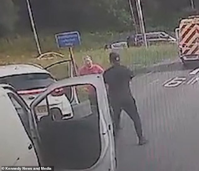 The couple then swings towards each other as traffic continues to pass them on the roundabout