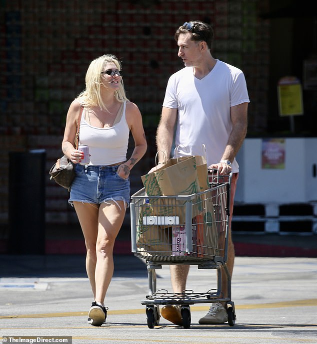 She looked casual in a low-cut white tank top and tiny denim shorts