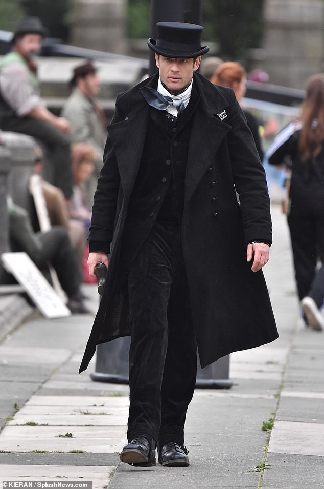 He looked handsome in a black suit which he paired with a white scarf, a long coat and a top hat.