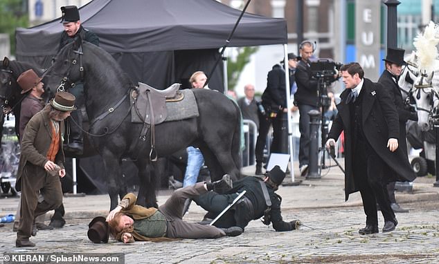 Two men were spotted on the ground as James filmed in Liverpool