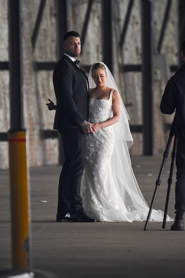 He had purple flowers pinned to his lapel and beamed at the cameras as the wedding began