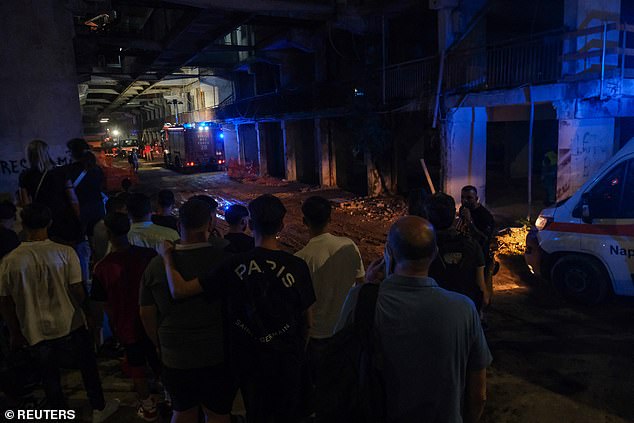 People wait outside the site of a collapsed balcony in Naples, Italy. Mayor Gaetano Manfredi said social services were sent to the scene on X to help residents