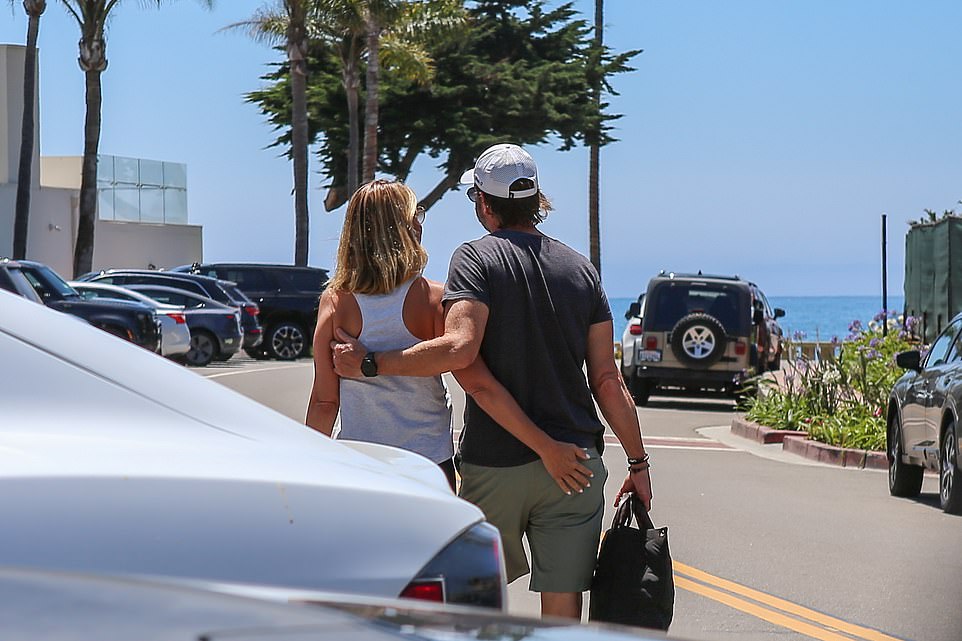 The couple had no problem touching each other at the exclusive club on Butterfly Beach, where membership costs $2,500 a month