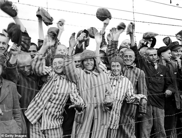 Young prisoners interned in the Dachau concentration camp cheer their liberators, the 42nd Division of the U.S. Army