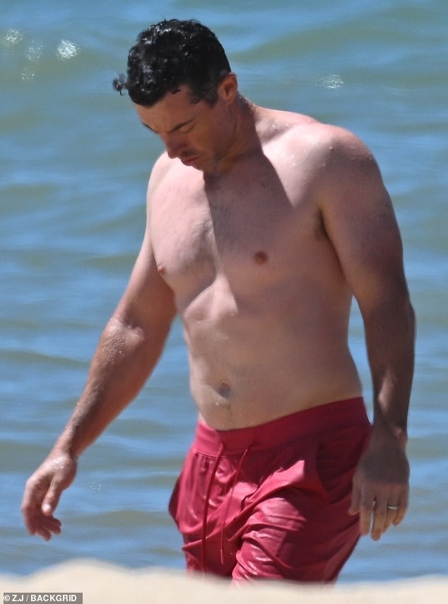 Rory wore red swimming trunks as he took a dip in the sea during his holiday with wife Erica