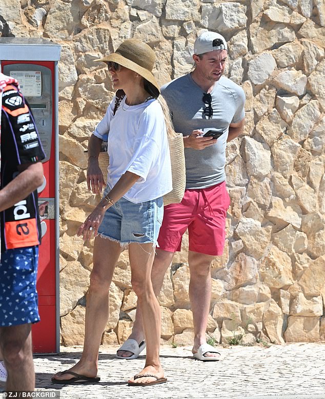 Erica was the epitome of chic beach fashion as she wore distressed denim shorts, a white shirt and a sun hat