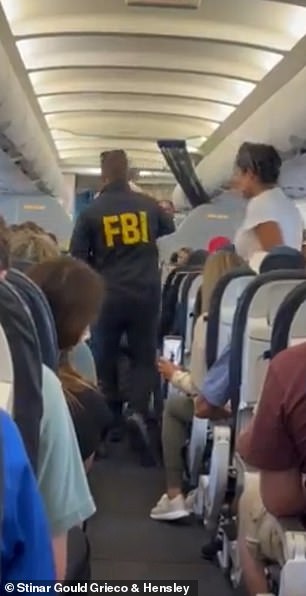 Terrell Davis is escorted off a plane by an FBI agent