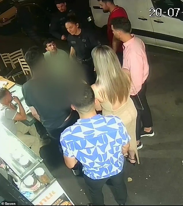 The Australian woman sought refuge in the kebab shop in Paris but was confronted by one of the men who had attacked her minutes earlier. Bystanders are pictured talking to the woman, who is blurred, and police