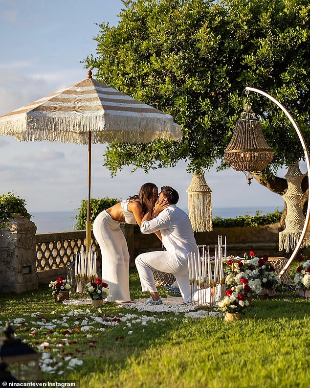 Several lanterns and red and white rose petals formed a path leading to the spot where Adrian knelt, surrounded by breathtaking views of the Italian coastline.