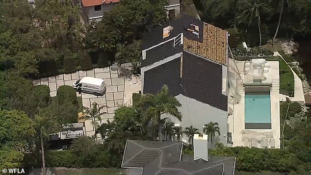 A coroner's van can be seen in front of the house after the raid